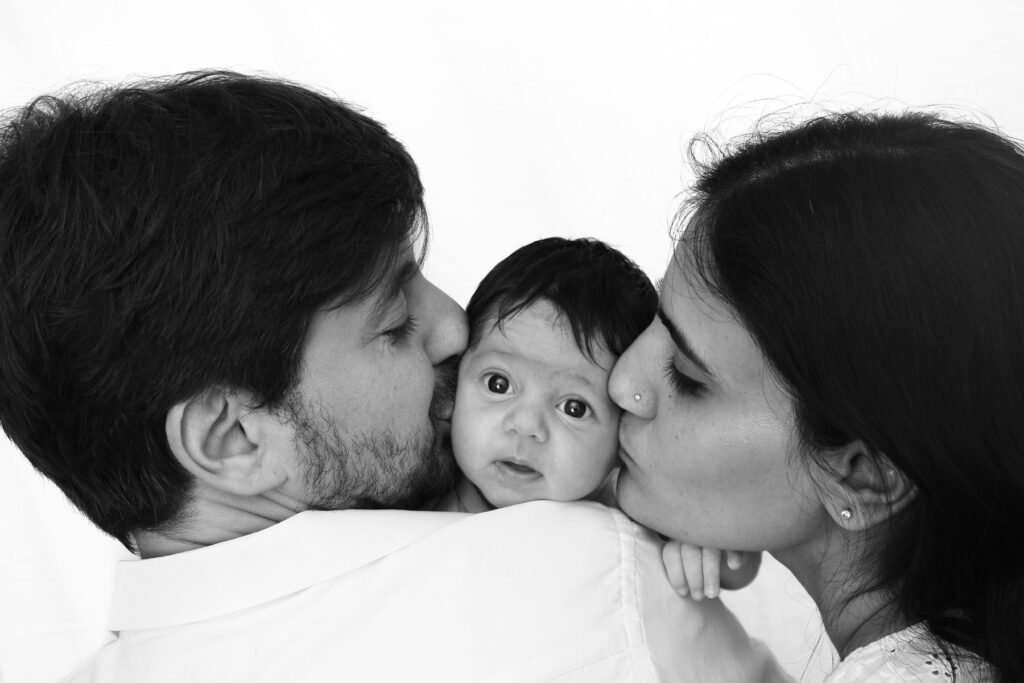 Parents kissing their kid, family photoshoot, kids photography family portrait