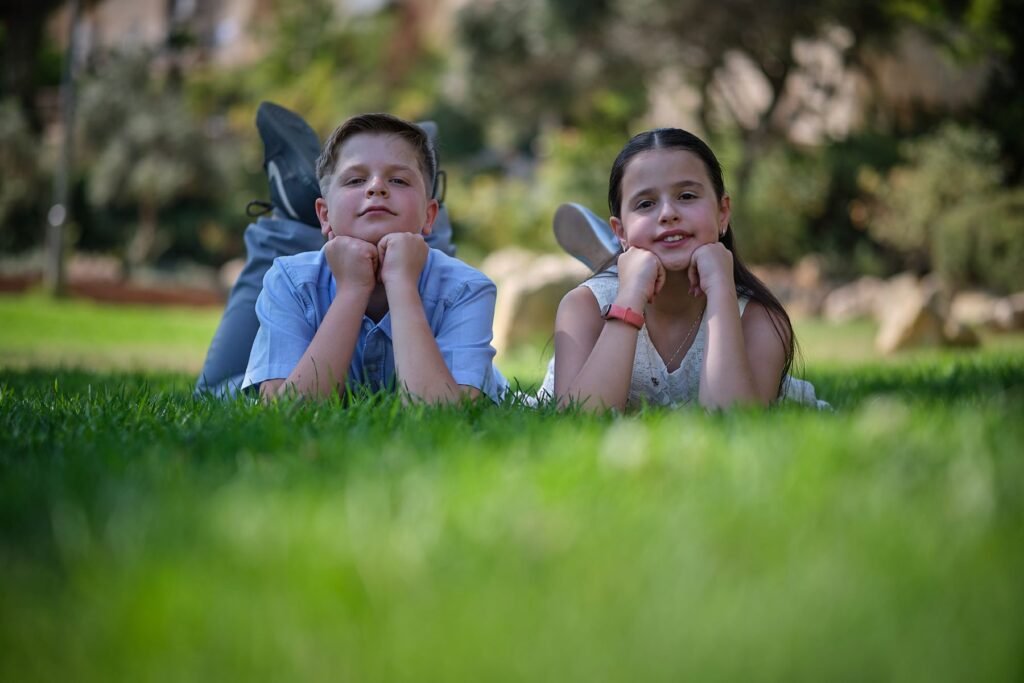 brother and sister on the grass, family portrait photography